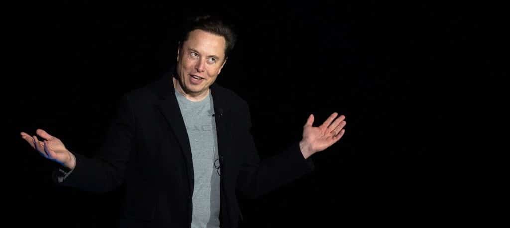 elon musk throws his hands in the air