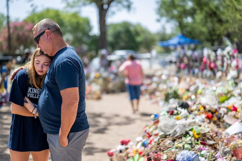Olivia Luna, 15, is comforted at a memorial in front of Robb Elementary School on June 17, 2022 in Uvalde, Texas.