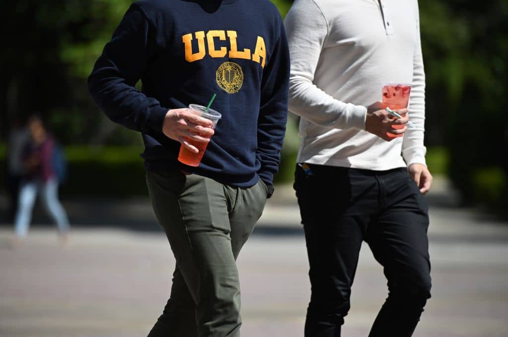 Students walk on the campus of University of California at Los Angeles (UCLA) in Los Angeles, California on March 11, 2020. - Starting this week many southern California universities including UCLA will suspend in-person classes due to coronavirus concerns. (Photo by Robyn Beck / AFP) (Photo by ROBYN BECK/AFP via Getty Images)
