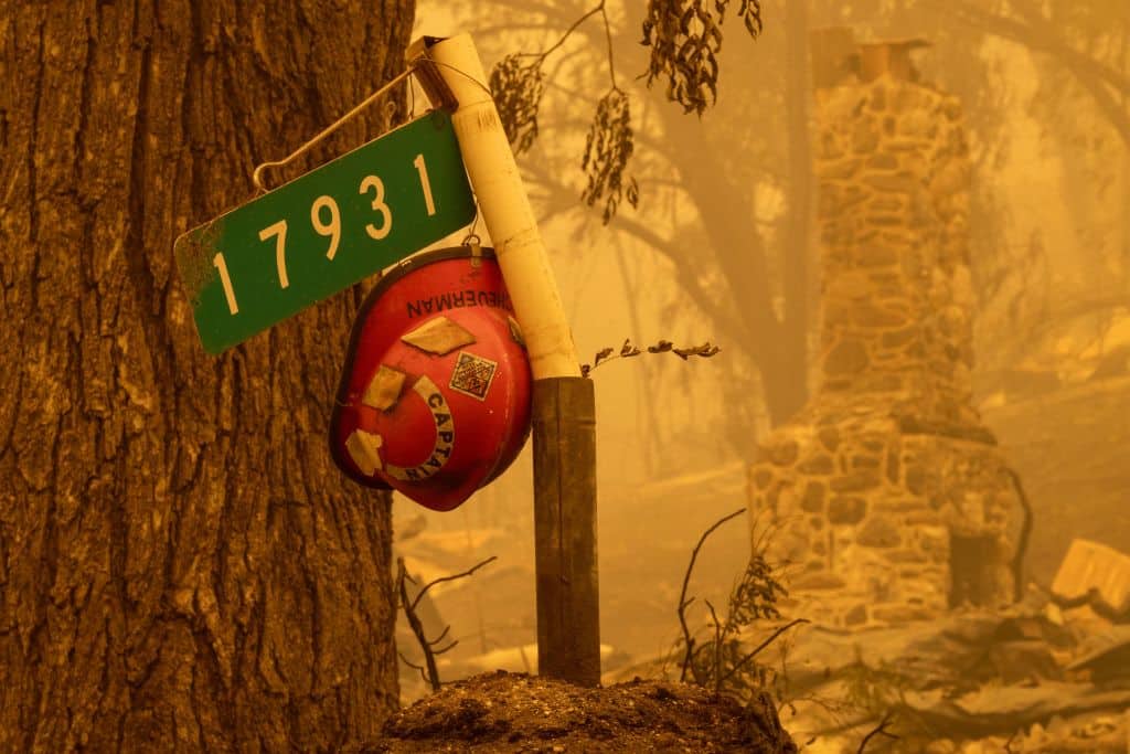 A firefighter helmet hangs at the entrance to a property in the community of Klamath River, which burned in the McKinney Fire, in Klamath National Forest, northwest of Yreka, California. July 31, 2022. (DAVID MCNEW/AFP via Getty Images)