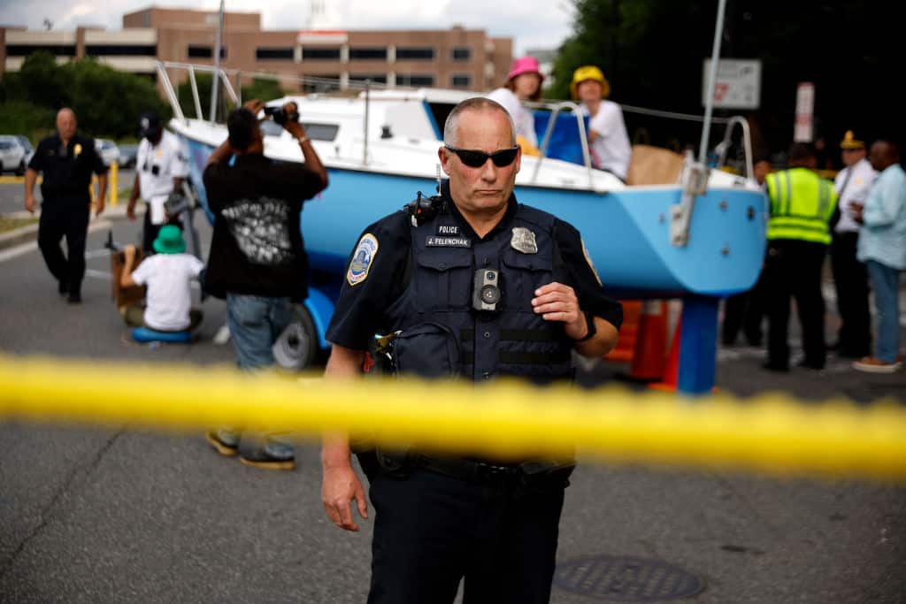 Metro DC Police isolate and surround a boat left in the middle of the street by members of Extinction Rebellion Washington to block traffic as part of their campaign to get fossil fuels out of the nation's capital on July 08, 2022 in Washington, DC.