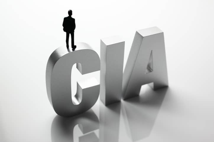 Government concept. Plastic toy businessman standing on top of block letter word - CIA.Similar images -