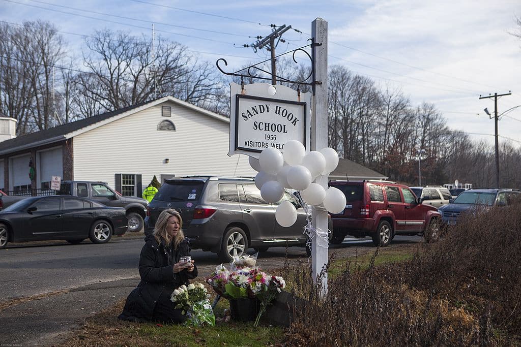 SANDY HOOK, CT - DECEMBER 15: Local residents place flowers near the Sandy Hook Elementary School December 15, 2012  in Sandy Hook, Connecticut for the 28 children and faculty shot and killed one day earlier on December 14, 2012. (Photo by Robert Nickelsberg/Getty Images)