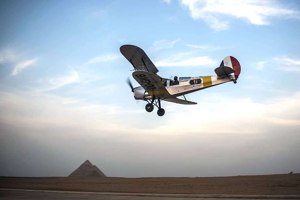 Belgian pilots Alexandra Maingard and her husband Cedric Collette fly their vintage  Stampe OO-GWB biplane near the Pyramids of Giza, on the southern outskirts of the Egyptian capital Cairo on November 13, 2016 during the Vintage Air Rally (VAR). 
A dozen biplanes from the 1920s and 1930s are flying 8,000 miles from Crete to Cape Town in a vintage aviation rally that harks back to the early days of air travel.  / AFP / KHALED DESOUKI        (Photo credit should read KHALED DESOUKI/AFP via Getty Images)