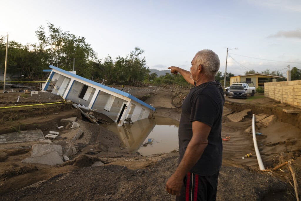 A man points to a home that was collapsed by Hurricane Fiona at Villa Esperanza in Salinas, Puerto Rico, Wednesday, September 21, 2022. (AP Photo/Alejandro Granadillo)