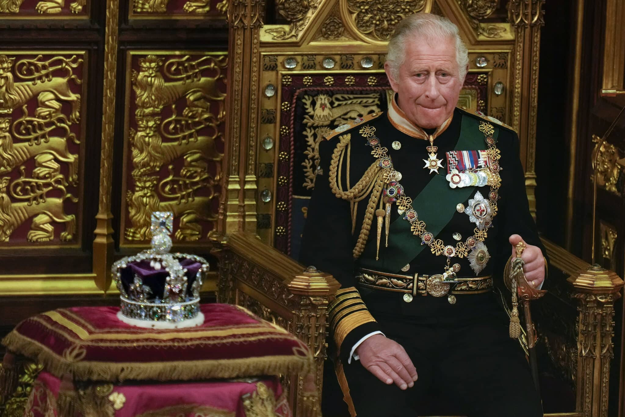 LONDON, ENGLAND - MAY 10: Prince Charles, Prince of Wales seated next to the Queen's Imperial State Crown in the House of Lords Chamber, during the State Opening of Parliament in the House of Lords at the Palace of Westminster on May 10, 2022 in London, England. The State Opening of Parliament formally marks the beginning of the new session of Parliament. It includes Queen's Speech, prepared for her to read from the throne, by her government outlining its plans for new laws being brought forward in the coming parliamentary year. This year the speech will be read by the Prince of Wales as HM The Queen will miss the event due to ongoing mobility issues. (Photo by Alastair Grant - WPA Pool/Getty Images)