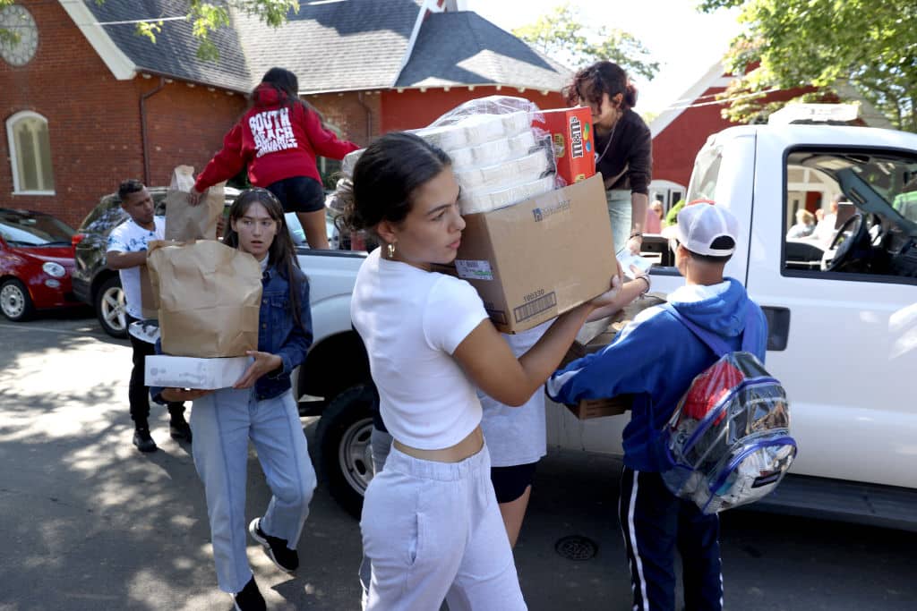 Martha's Vineyard, MA - September 15: Students from the Marthas Vineyard Regional High School AP Spanish class help deliver food to St Andrews Episcopal Church. Two planes of migrants from Venezuela arrived suddenly Wednesday night on Martha's Vineyard. The students served as translators for the migrants. (Photo by Jonathan Wiggs/The Boston Globe via Getty Images)