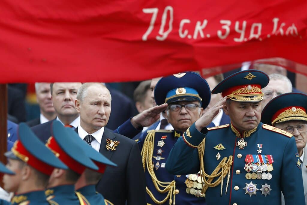 FILE - In this file photo taken on Thursday, May 9, 2019, Russian President Vladimir Putin, left, and Russian Defense Minister Sergei Shoigu, right, attend a wreath-laying ceremony at the Tomb of the Unknown Soldier after the military parade marking 74 years since the victory in WWII in Moscow, Russia. A massive military parade that was postponed by the coronavirus will roll through Red Square this week to celebrate the 75th anniversary of the end of World War II in Europe, even though Russia is continuing to register a steady rise in infections. (AP Photo/Pavel Golovkin, File)