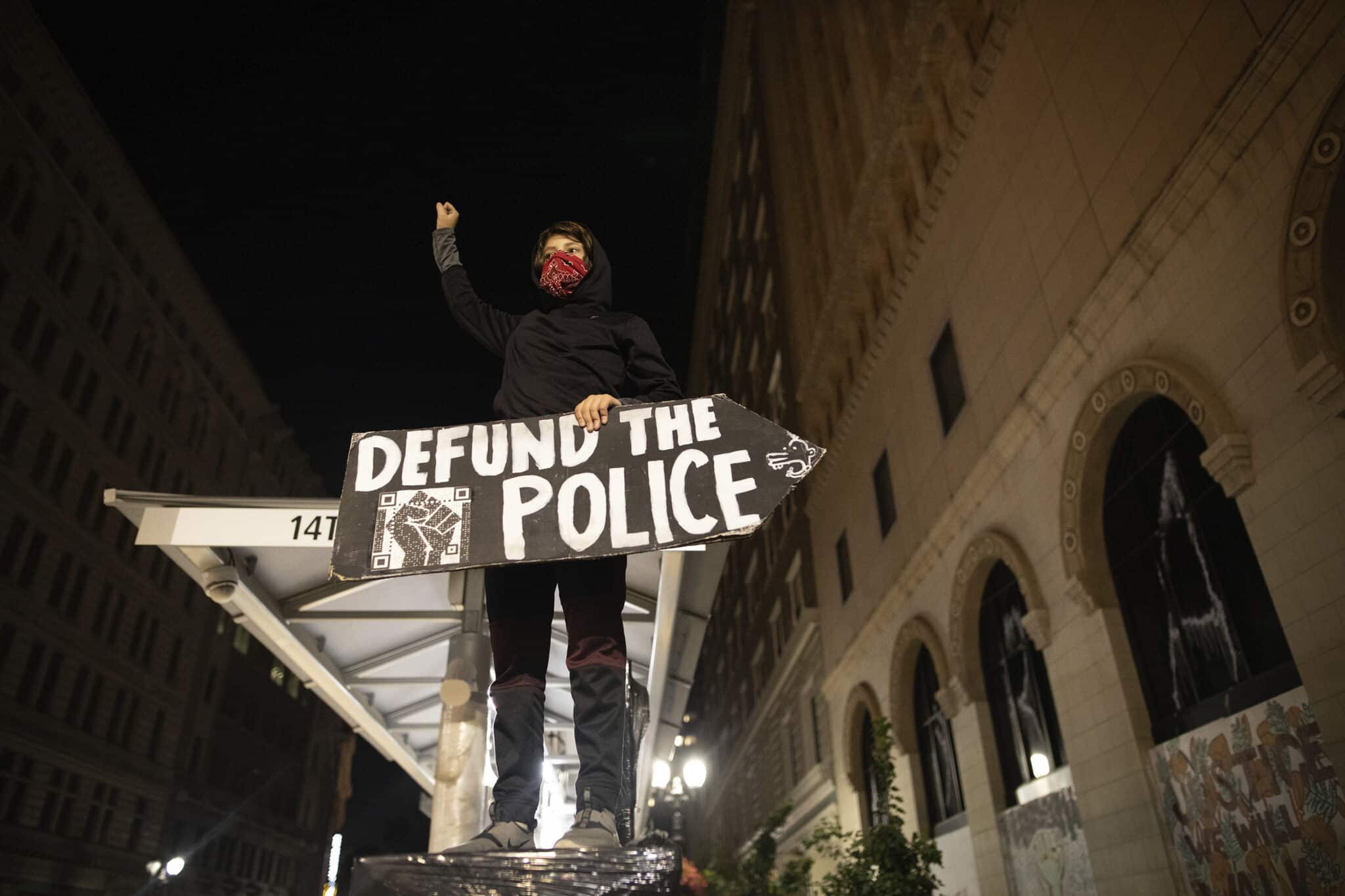 FILE - A protester holds a sign calling for the defunding of police at a protest on July 25, 2020, in Oakland, Calif. Oakland officials will reverse plans to cut police funding and seek to hire more officers as soon as possible, Mayor Libby Schaaf said Monday, Nov. 29, 2021, as a spate of gun violence and fatal shootings has left residents on edge. (AP Photo/Christian Monterrosa, File)