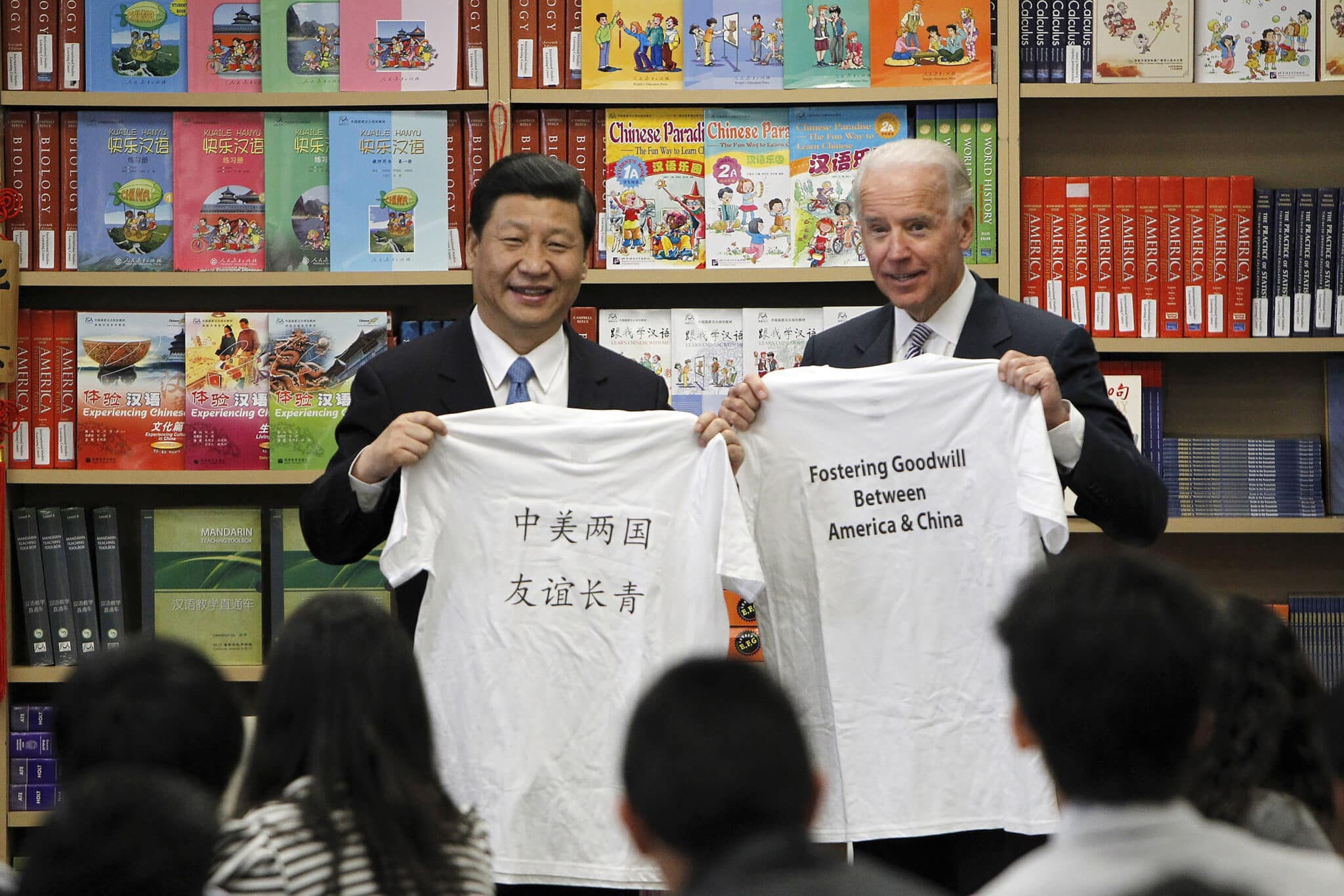 FILE - Then Chinese Vice President Xi Jinping, left, and then U.S. Vice President Joe Biden hold t-shirts given to them by students during their visit to the International Studies Learning Center in South Gate, Calif. Feb. 17, 2012. When Xi Jinping came to power in 2012, it wasn't clear what kind of leader he would be. His low-key persona during a steady rise through the ranks of the Communist Party gave no hint that he would evolve into one of modern China's most dominant leaders, or that he would put the economically and militarily ascendant country on a collision course with the U.S.-led international order. (AP Photo/Damian Dovarganes, File)