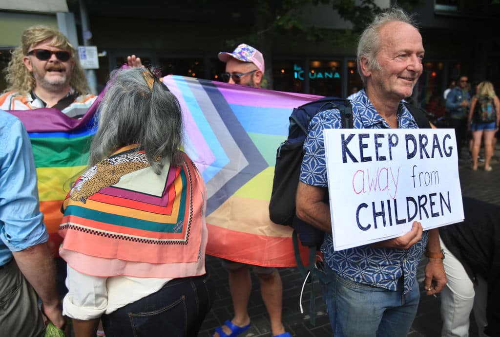 BRIGHTON, ENGLAND - AUGUST 04:  A protester against drag queens reading to children holds a sign saying 'Keep Drag Away From Kids' as both protesting groups come together outside Jubilee library on August 04, 2022 in Brighton, United Kingdom. Drag Queen Story Hour, an established and ticketed children's entertainment provider, has been faced with disruptive protests as the show tours libraries around England. (Photo by Martin Pope/Getty Images)