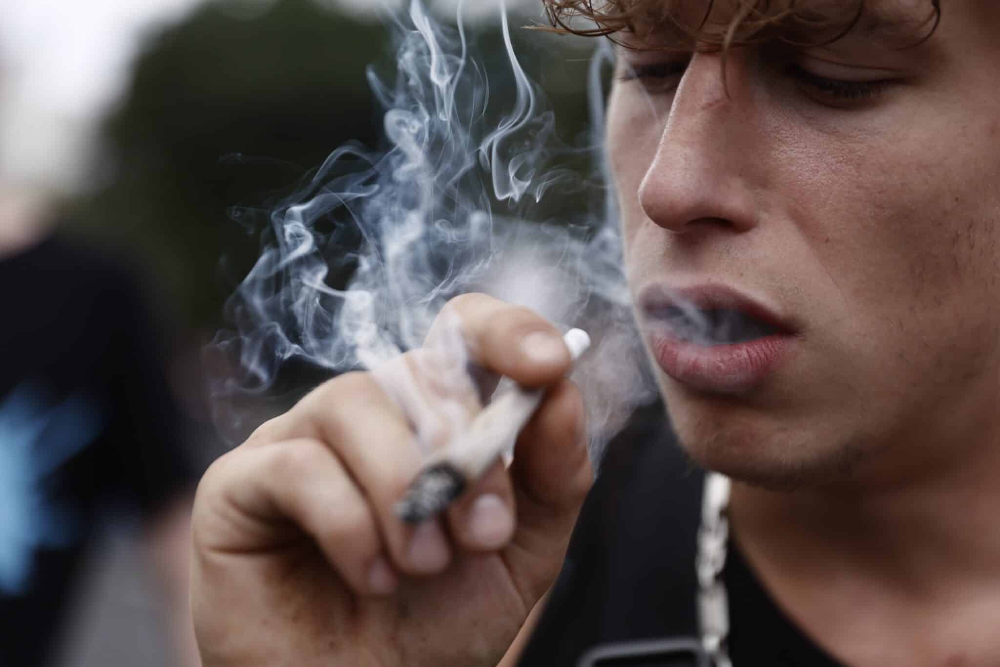 BERLIN, GERMANY - AUGUST 13: An participant smokes as activists demonstrating for the legalisation of marijuana march in the annual Hemp Parade (Hanfparade) on August 13, 2022 in Berlin, Germany. So far owning, cultivating and selling cannabis in Germany is still illegal, though the current coalition government campaigned on cannabis legalisation and is scheduled to begin debating corresponding legislation in coming months. (Photo by Carsten Koall/Getty Images)