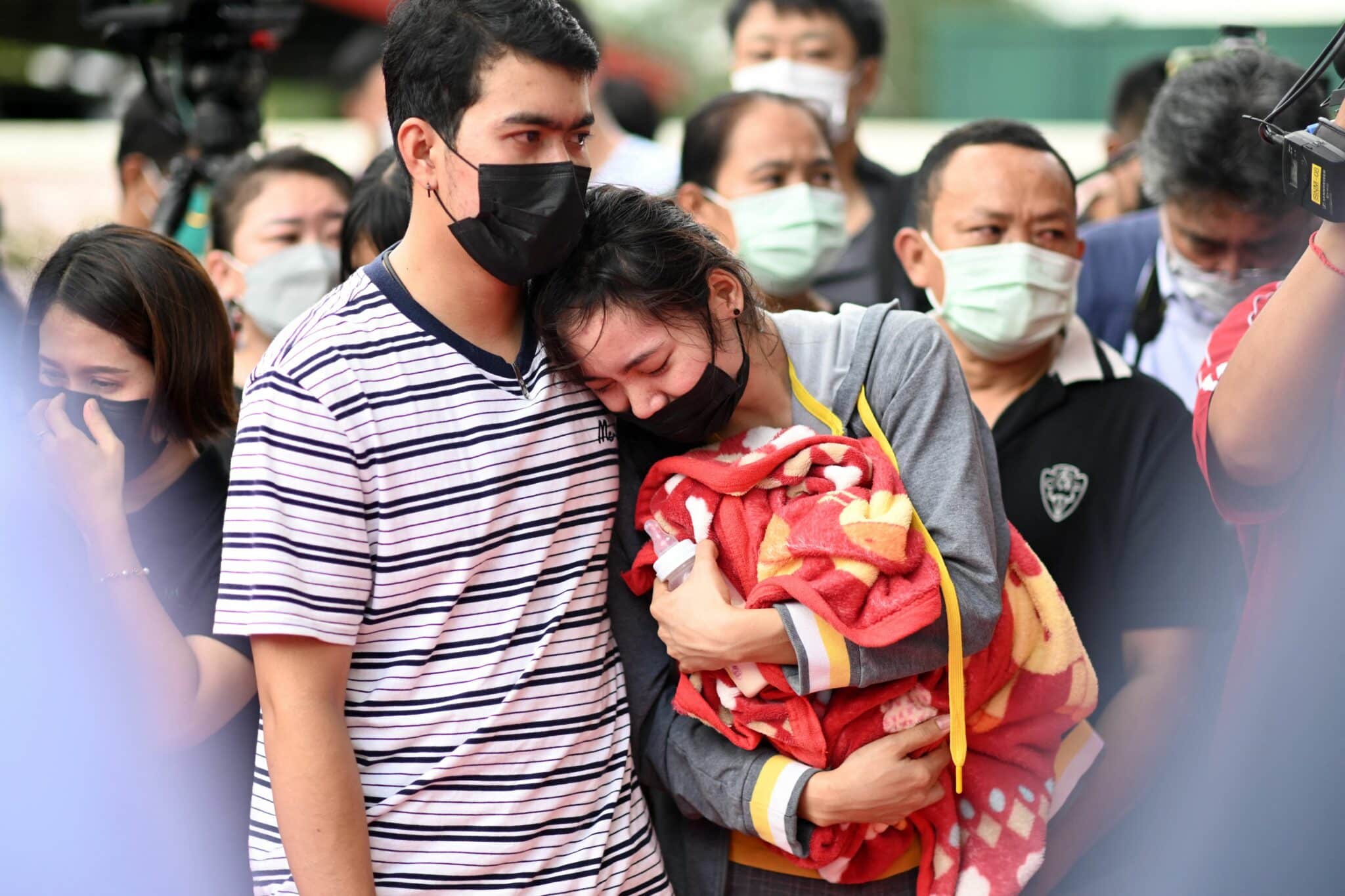 The mother of a victim holds a milk bottle and blanket as she reacts while standing outside the nursery in Na Klang in Thailand's northeastern Nong Bua Lam Phu province on October 7, 2022, the day after a former police officer killed at least 37 people in a mass shooting at the site. - Weeping, grief-stricken families gathered on October 7 outside a Thai nursery where an ex-policeman murdered nearly two dozen children in one of the kingdom's worst mass killings. (Photo by Manan VATSYAYANA / AFP) (Photo by MANAN VATSYAYANA/AFP via Getty Images)