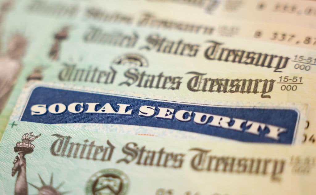 WASHINGTON, DC - OCTOBER 14: In this photo illustration, a Social Security card sits alongside checks from the U.S. Treasury on October 14, 2021 in Washington, DC. The Social Security Administration announced recipients will receive an annual cost of living adjustment of 5.9%, the largest increase since 1982. The larger increase is aimed at helping to offset rising inflation. (Photo illustration by Kevin Dietsch/Getty Images)