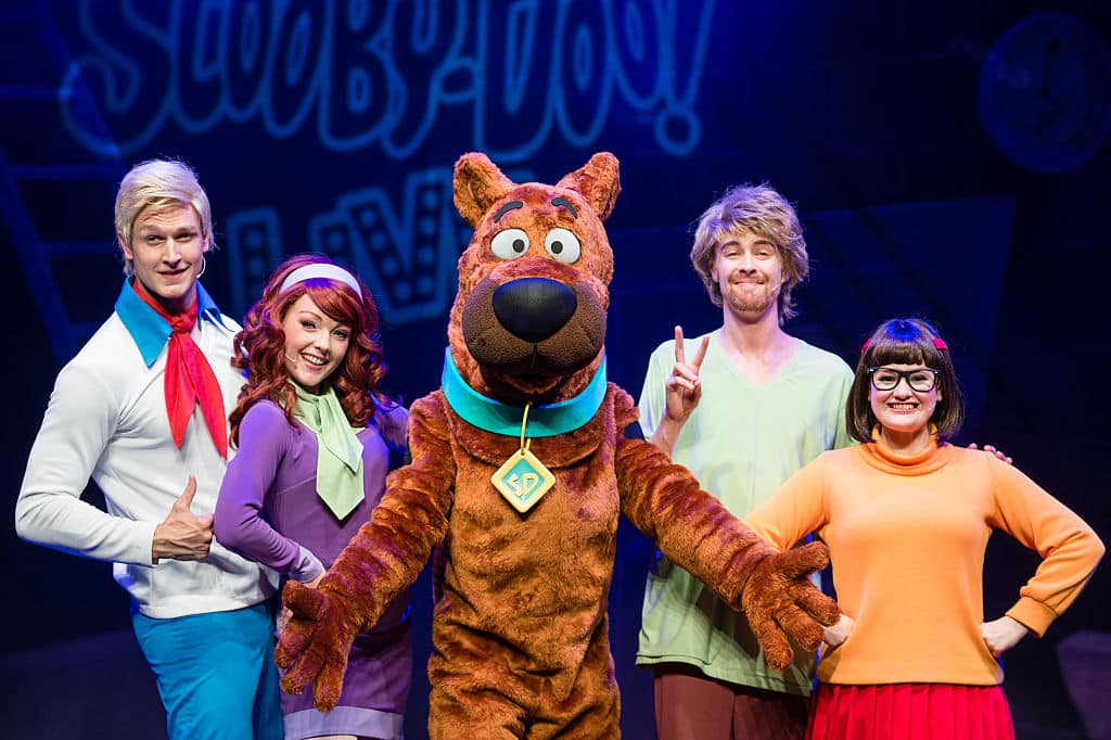 LONDON, ENGLAND - AUGUST 17:  (L-R) Chris Warner Drake as Fred, Charlie Bull as Daphne, Joe Goldie as Scooby-Doo, Charlie Haskins as Shaggy and Rebecca Withers as Velma appear on stage in Scooby-Doo Live!  at London Palladium on August 17, 2016 in London, England.  (Photo by Jeff Spicer/Getty Images)