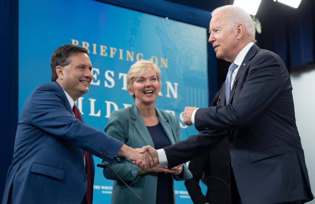US President Joe Biden shakes hands with White House Chief of Staff Ron Klain (L) alongside Secretary of Energy Jennifer Granholm (C) as he arrives for a briefing on wildfires ahead of the wildfire season with cabinet members, government officials, as well as governors of several western states, in the Eisenhower Executive Office Building in Washington, DC, June 30, 2021. (Photo by SAUL LOEB / AFP) (Photo by SAUL LOEB/AFP via Getty Images)