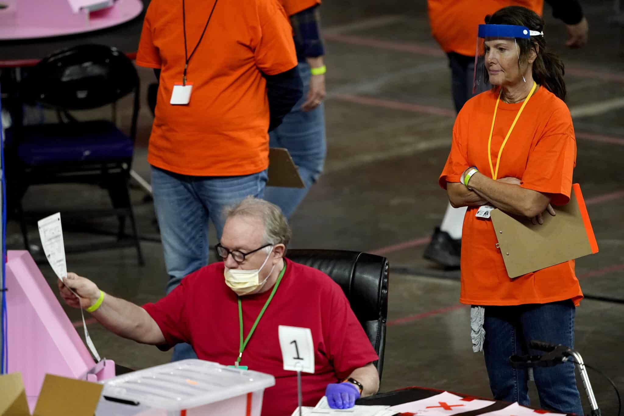 FILE - Maricopa County ballots cast in the 2020 general election are examined and recounted by contractors working for Florida-based company, Cyber Ninjas at Veterans Memorial Coliseum in Phoenix, May 6, 2021. A judge has blocked a rural Arizona county's plan to hand-count all the ballots in the Nov. 8, 2022, election. The full hand-count was ordered by Republican officials in Cochise County who have made unfounded claims that vote-counting machines are untrustworthy. The ruling on Monday, Nov. 7, from Pima County Superior Court Judge Casey F. McGinley came after a full-day hearing late the week before, in which opponents spoke out against the proposal. (AP Photo/Matt York, Pool,File)