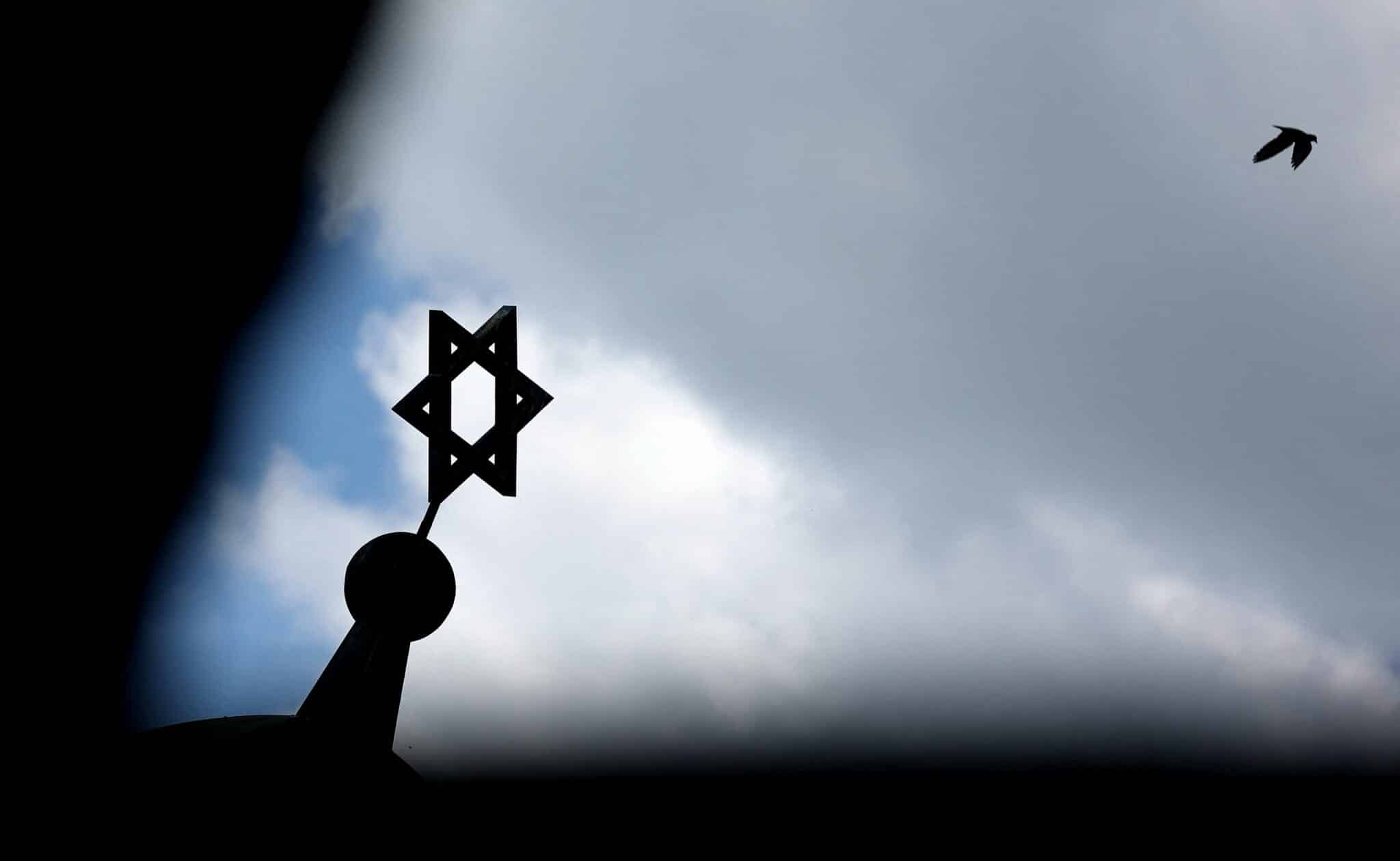 A bird flies past as the Star of David is seen on top of the synagogue in Halle, eastern Germany, on May 30, 2021. - In October 2019, Germany was rocked by a shooting at the synagogue in the eastern city of Halle that left two people dead. Neo-Nazi Stephan Balliet was sentenced to life in prison in December for that attack, described as the country's worst anti-Semitic atrocity since World War II. Balliet, heavily armed, tried to storm the synagogue, but when the door failed to break down he shot dead a female passer-by and a man at a kebab shop instead. (Photo by Ronny Hartmann / AFP) (Photo by RONNY HARTMANN/AFP via Getty Images)