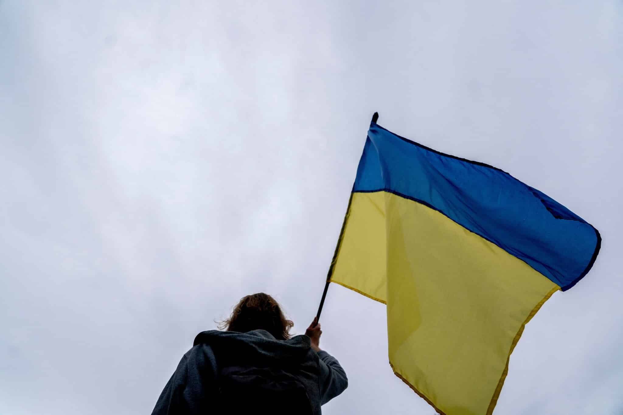 TOPSHOT - A demonstrator carries the flag of Ukraine during a rally at the World War II memorial in Washington, DC, on May 1, 2022. (Photo by Stefani Reynolds / AFP) (Photo by STEFANI REYNOLDS/AFP via Getty Images)