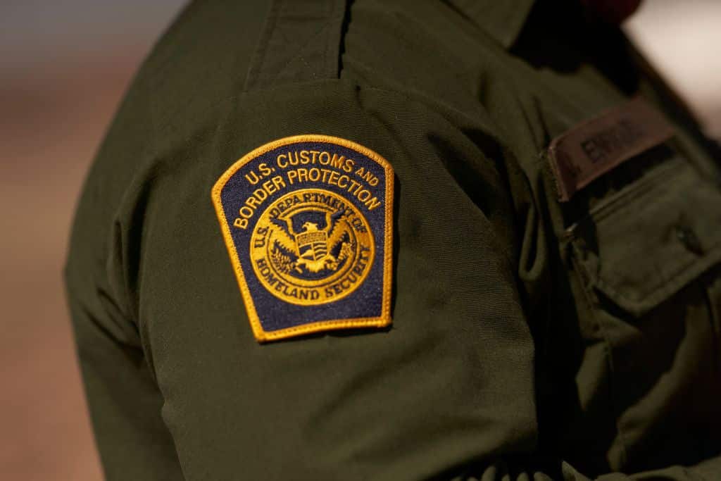 A US Customs and Border Protection patch is seen on the arm of an agent in the Jacumba mountains on October 6, 2022 in Imperial County, California. - In the fiscal year 2022 the number of migrant apprehensions exceeded 2 million, a new record in US Border Patrol history, but these apprehensions include many repeat offenders. (Photo by allison dinner / AFP) (Photo by ALLISON DINNER/AFP via Getty Images)
