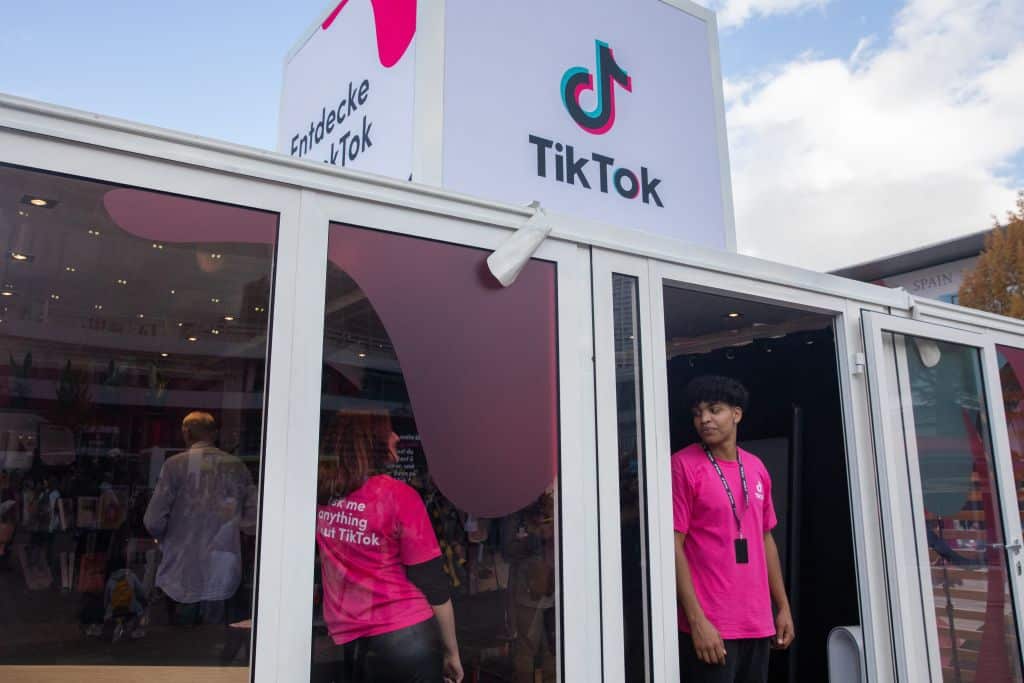 Employees stand at the entrance of a TikTok booth at the Messe fairground during the 23rd Frankfurt Book Fair in Frankfurt am Main on October 22, 2022. - This year's edition of the Frankfurt Book Fair takes place until October 23 at the Messe Frankfurt fairground. (Photo by ANDRE PAIN / AFP) (Photo by ANDRE PAIN/AFP via Getty Images)
