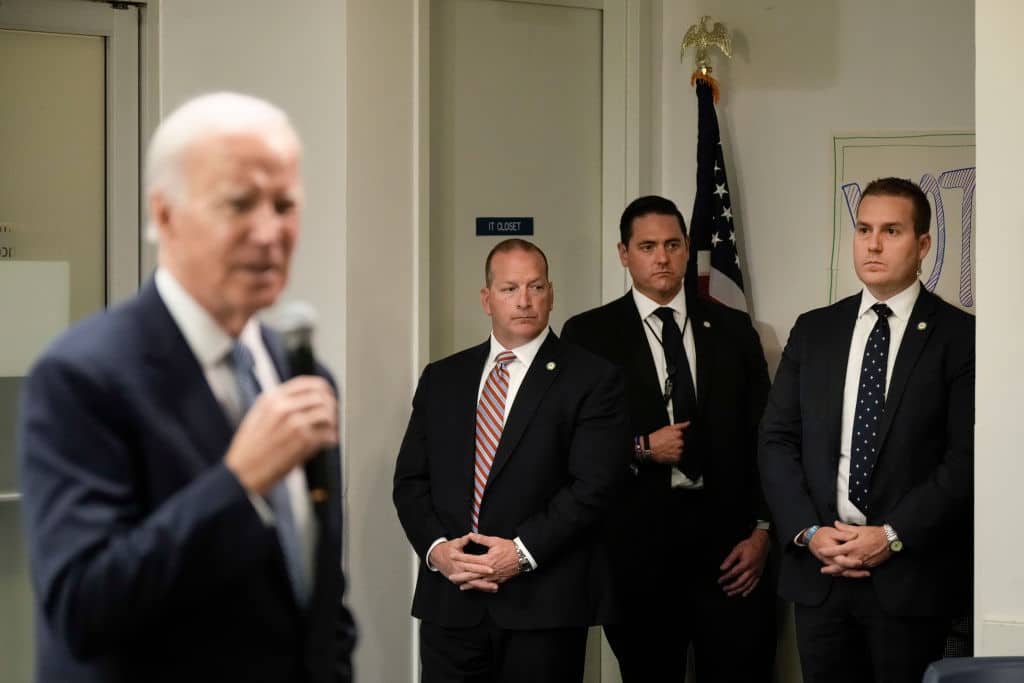WASHINGTON, DC - OCTOBER 24: Members of the U.S. Secret Service stand watch as U.S. President Joe Biden speaks at the headquarters of the Democratic National Committee (DNC) October 24, 2022 in Washington, DC. Biden spoke to staff and volunteers about the midterm elections, which are now two weeks away. (Photo by Drew Angerer/Getty Images)