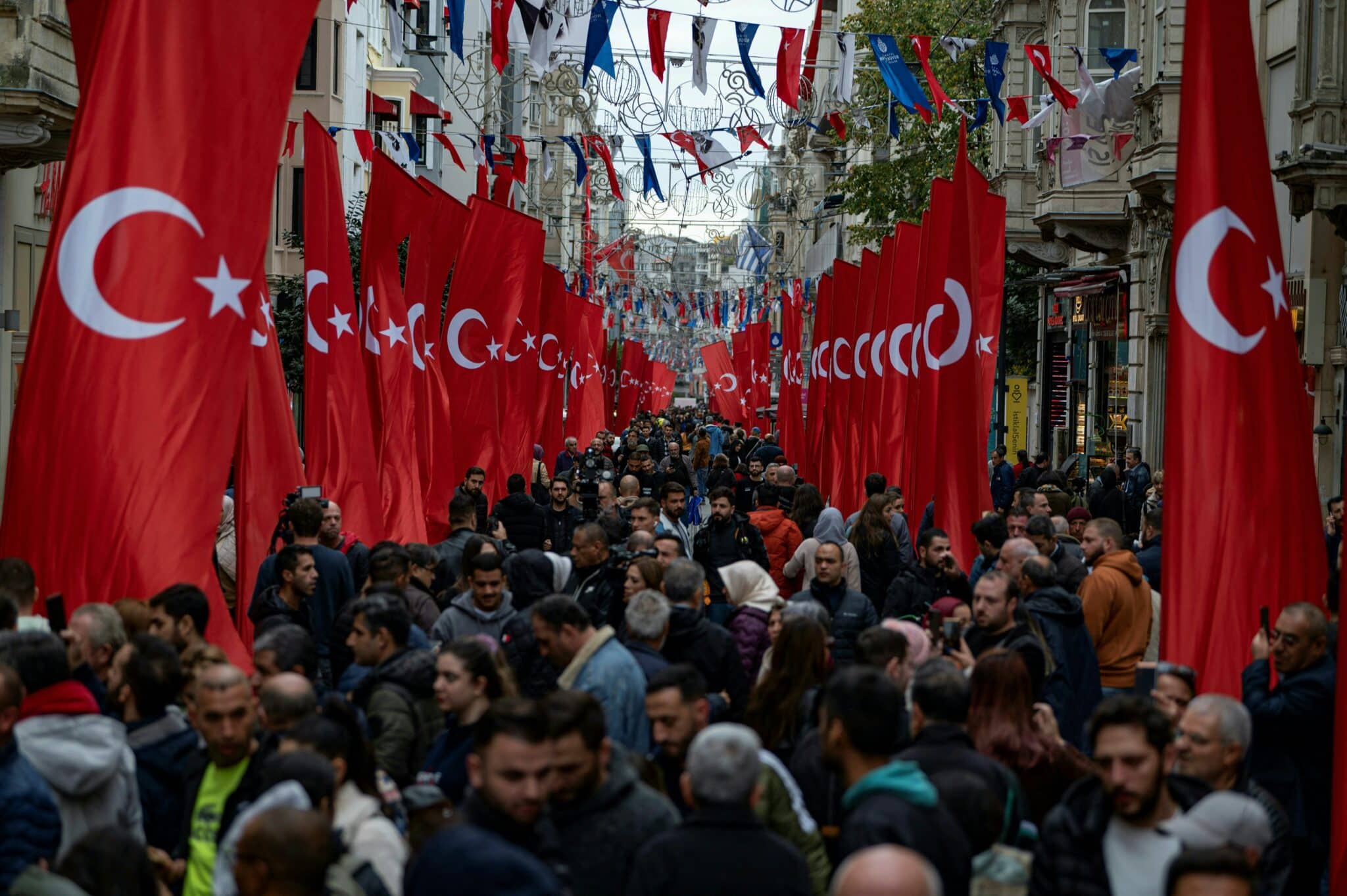TOPSHOT - Pedestrians walk through Istiklal street in Istanbul, adorned all along with Turkish national flags on November 14, 2022 one day after a bomb killed six people in the busy central shopping street of the Turkish capital. - Turkey's interior minister accused the outlawed Kurdistan Workers' Party (PKK) on November 14, of responsibility for a bombing in a busy Istanbul street that killed six people and wounded scores, saying more than 20 people have been arrested. (Photo by Yasin AKGUL / AFP) (Photo by YASIN AKGUL/AFP via Getty Images)