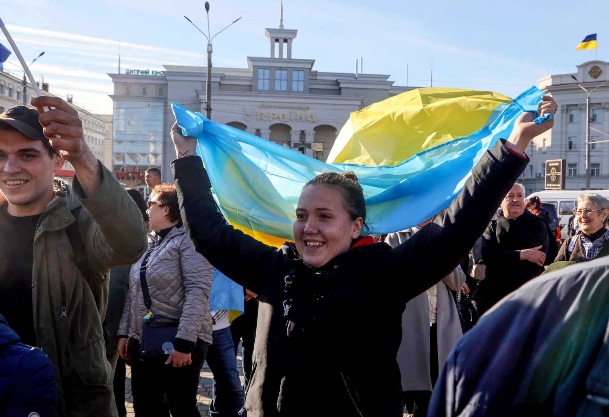 A woman waves a Ukrainian flag in the centre of the recently recaptured city of Kherson on November 14, 2022. - The takeover by Ukrainian troops of the Kherson region is the latest in a string of setbacks for Russia, which invaded Ukraine on February 24 hoping for a lightning takeover and to topple the government in days. (Photo by Oleksandr GIMANOV / AFP) (Photo by OLEKSANDR GIMANOV/AFP via Getty Images)
