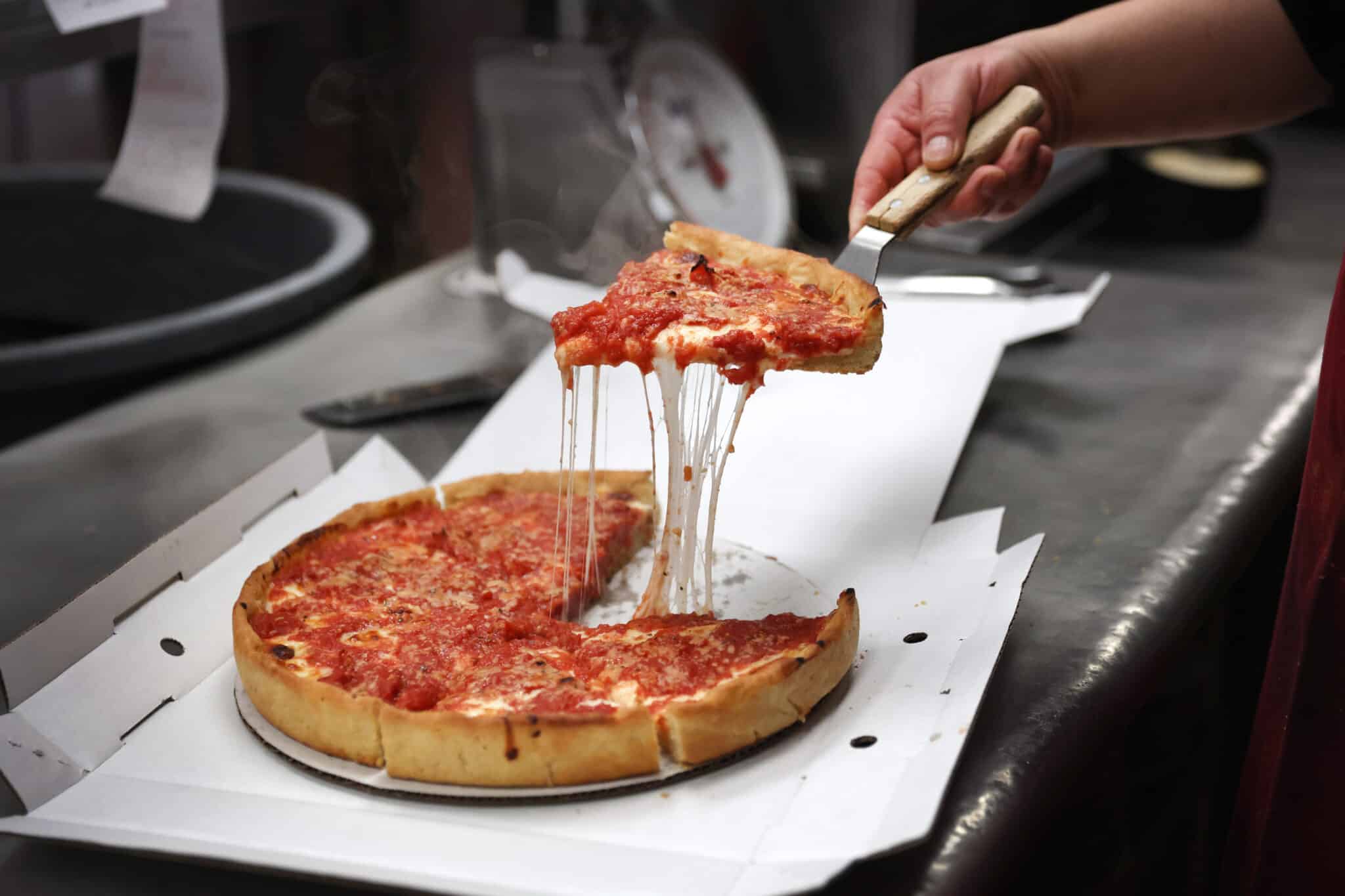 CHICAGO, ILLINOIS - MARCH 31: A worker prepares a Chicago-style deep dish pizza at a Lou Malnati's restaurant on March 31, 2022 in Chicago, Illinois. Restaurants, like the family-owned Lou Malnati's, have been hit by rising commodities prices such as wheat, which hit a record high after the start of the war in Ukraine.   (Photo Illustration by Scott Olson/Getty Images)