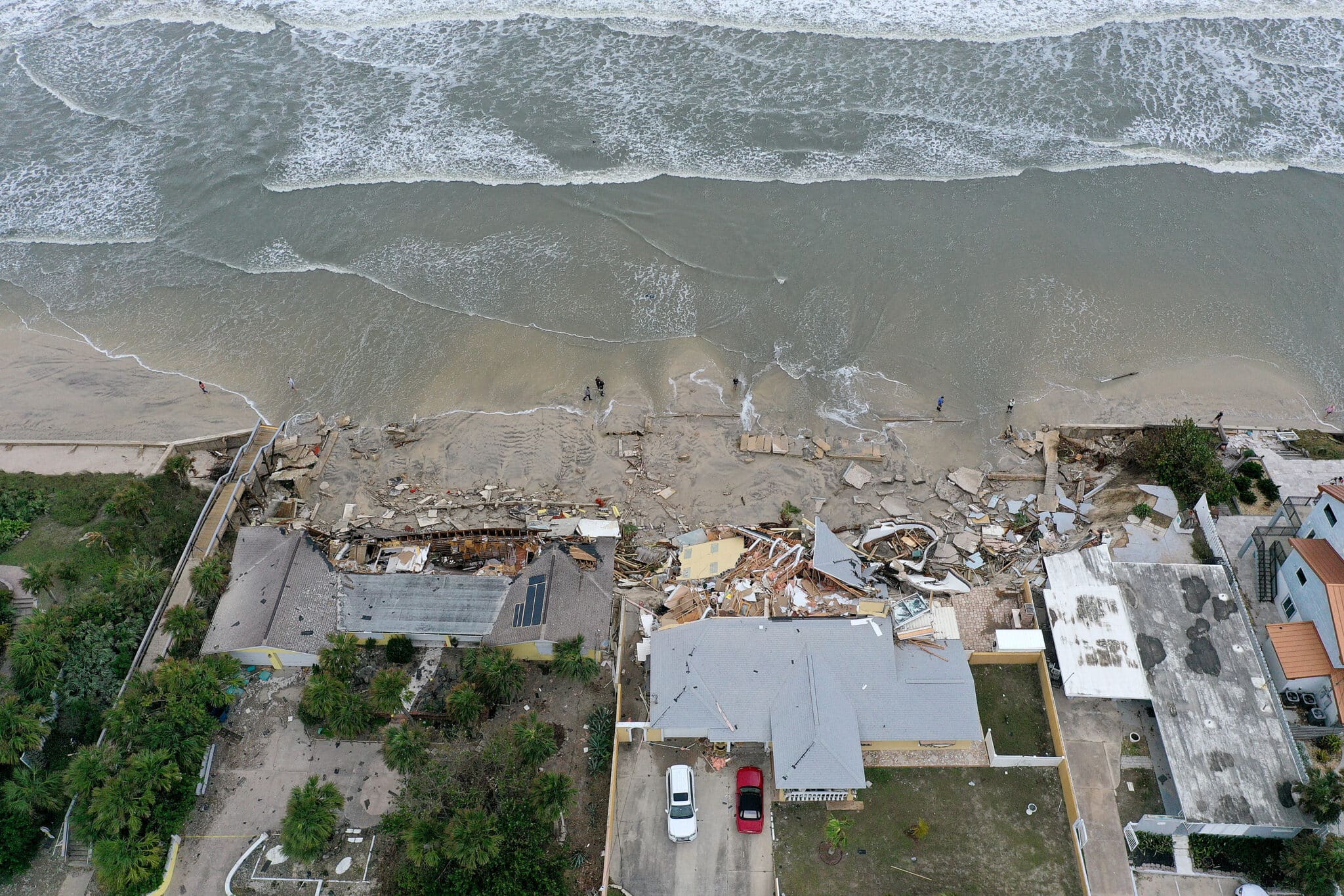 DAYTONA BEACH, FLORIDA - NOVEMBER 10: In this aerial view, homes are partially toppled onto the beach after Hurricane Nicole came ashore on November 10, 2022 in Daytona Beach, Florida. Nicole came ashore as a Category 1 hurricane before weakening to a tropical storm as it moved across the state. (Photo by Joe Raedle/Getty Images)
