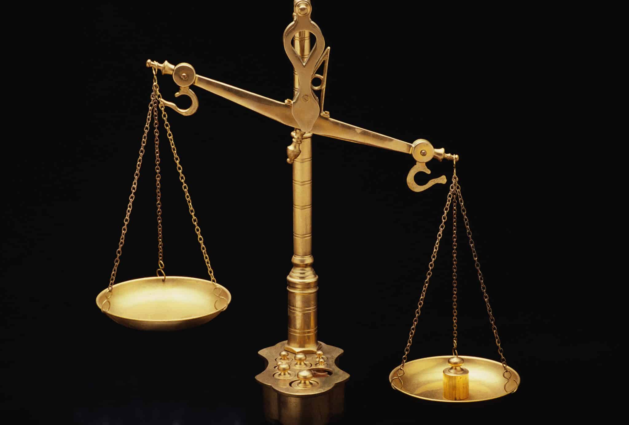 These are the golden Scales of Justice, They represent the legal system and courts, The scales here are shown unbalanced with the left side weighing heavier than the right, They are shown against a black background. (Photo by: Joe Sohm/Visions of America/Universal Images Group via Getty Images)