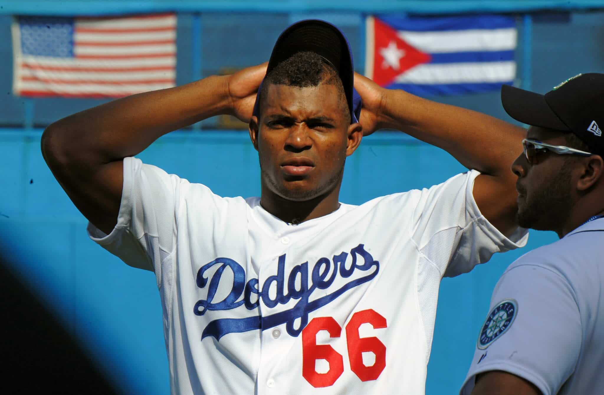 Cuban MLB player Yasiel Puig gestures during a children baseball training session at the Latin American Stadium in Havana, on December 16, 2015. Cuban baseball stars Jose Abreu and Yasiel Puig returned home Tuesday for the first time since defecting to join the American big leagues, part of an unprecedented Major League Baseball tour made possible by the thaw in US-Cuban relations. The delegation also includes Cuban-born player Alexei Ramirez, a free agent who left Cuba legally by marrying a Dominican in 2007.    / AFP / YAMIL LAGE        (Photo credit should read YAMIL LAGE/AFP via Getty Images)