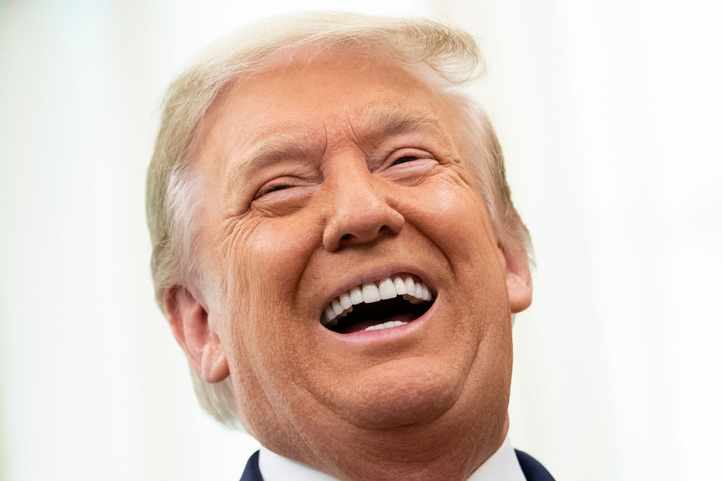 US President Donald Trump laughs during a Medal of Freedom ceremony for Lou Holtz in the Oval Office of the White House on December 3, 2020, in Washington, DC. (Photo by Brendan Smialowski / AFP) (Photo by BRENDAN SMIALOWSKI/AFP via Getty Images)