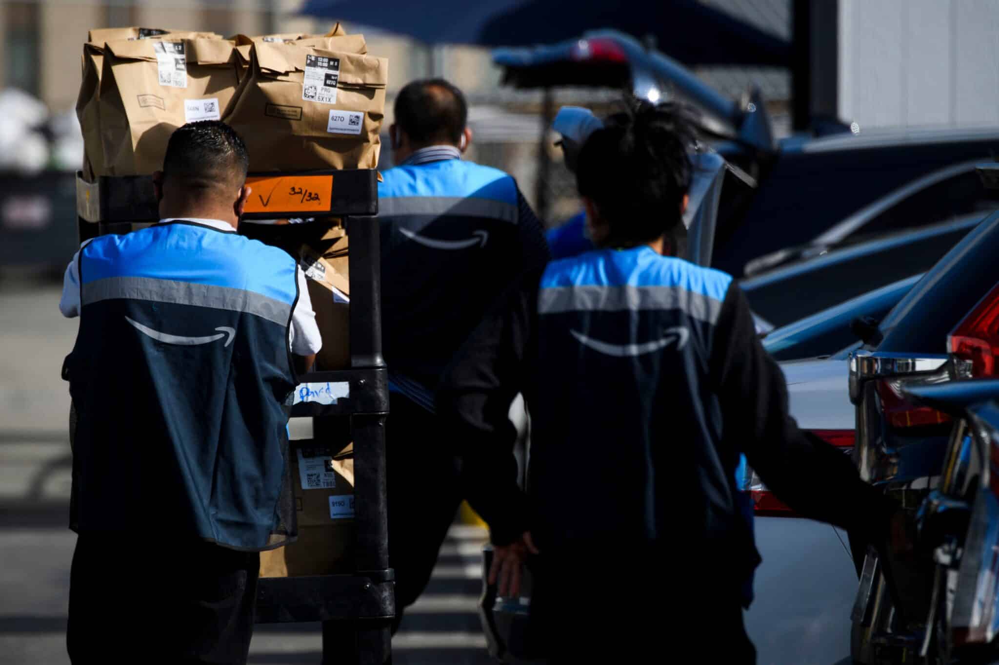 An Amazon.com Inc. delivery driver scans bags of groceries while loading a vehicle outside of a distribution facility on February 2, 2021 in Redondo Beach, California. - Jeff Bezos said February 1, 2021, he would give up his role as chief executive of Amazon later this year as the tech and e-commerce giant reported a surge in profit and revenue in the holiday quarter. The announcement came as Amazon reported a blowout holiday quarter with profits more than doubling to $7.2 billion and revenue jumping 44 percent to $125.6 billion. (Photo by Patrick T. FALLON / AFP) (Photo by PATRICK T. FALLON/AFP via Getty Images)