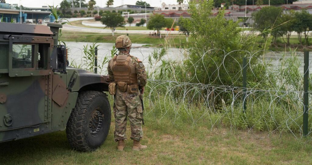 A National Guard soldier stands by as Texas Governor Greg Abbott tours the US-Mexico border at the Rio Grande River in Eagle Pass, Texas, on May 23, 2022. - A Louisiana federal judge blocked the Biden administration on Friday from ending Title 42, a pandemic-related border restriction that allows for the immediate expulsion of asylum-seekers and other migrants. (Photo by allison dinner / AFP) (Photo by ALLISON DINNER/AFP via Getty Images)