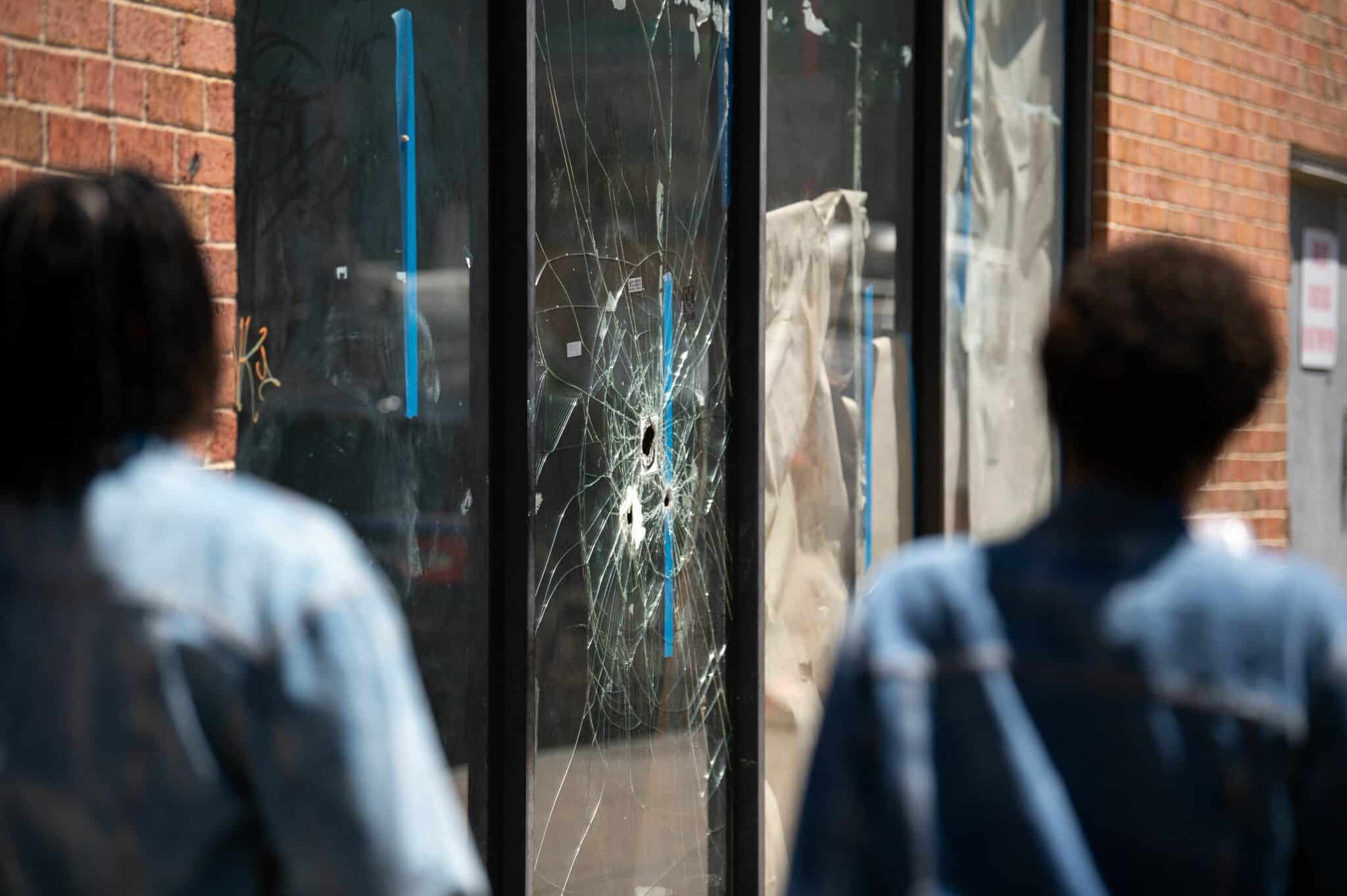 Pedestrians walk past bullet holes in the window of a store front on South Street in Philadelphia, Pennsylvania, on June 5, 2022. (Photo by Kriston Jae Bethel / AFP) / The erroneous mention[s] appearing in the metadata of this photo by Kriston Jae Bethel has been modified in AFP systems in the following manner: [Pedestrians walk past bullet holes in the window of a store front on South Street in Philadelphia, Pennsylvania, on June 5, 2022.] instead of [Pedestrians walk past bullet holes in the window of a store front on South Street in Philadelphia, Pennsylvania, on June 5, 2022, the day after a mass shooting left three dead and multiple people injured. Three people were killed and 11 others wounded late on June 4, 2022, in the US city of Philadelphia after multiple shooters opened fire into a crowd on a busy street, police said.]. Please immediately remove the erroneous mention[s] from all your online services and delete it (them) from your servers. If you have been authorized by AFP to distribute it (them) to third parties, please ensure that the same actions are carried out by them. Failure to promptly comply with these instructions will entail liability on your part for any continued or post notification usage. Therefore we thank you very much for all your attention and prompt action. We are sorry for the inconvenience this notification may cause and remain at your disposal for any further information you may require. (Photo by KRISTON JAE BETHEL/AFP via Getty Images)