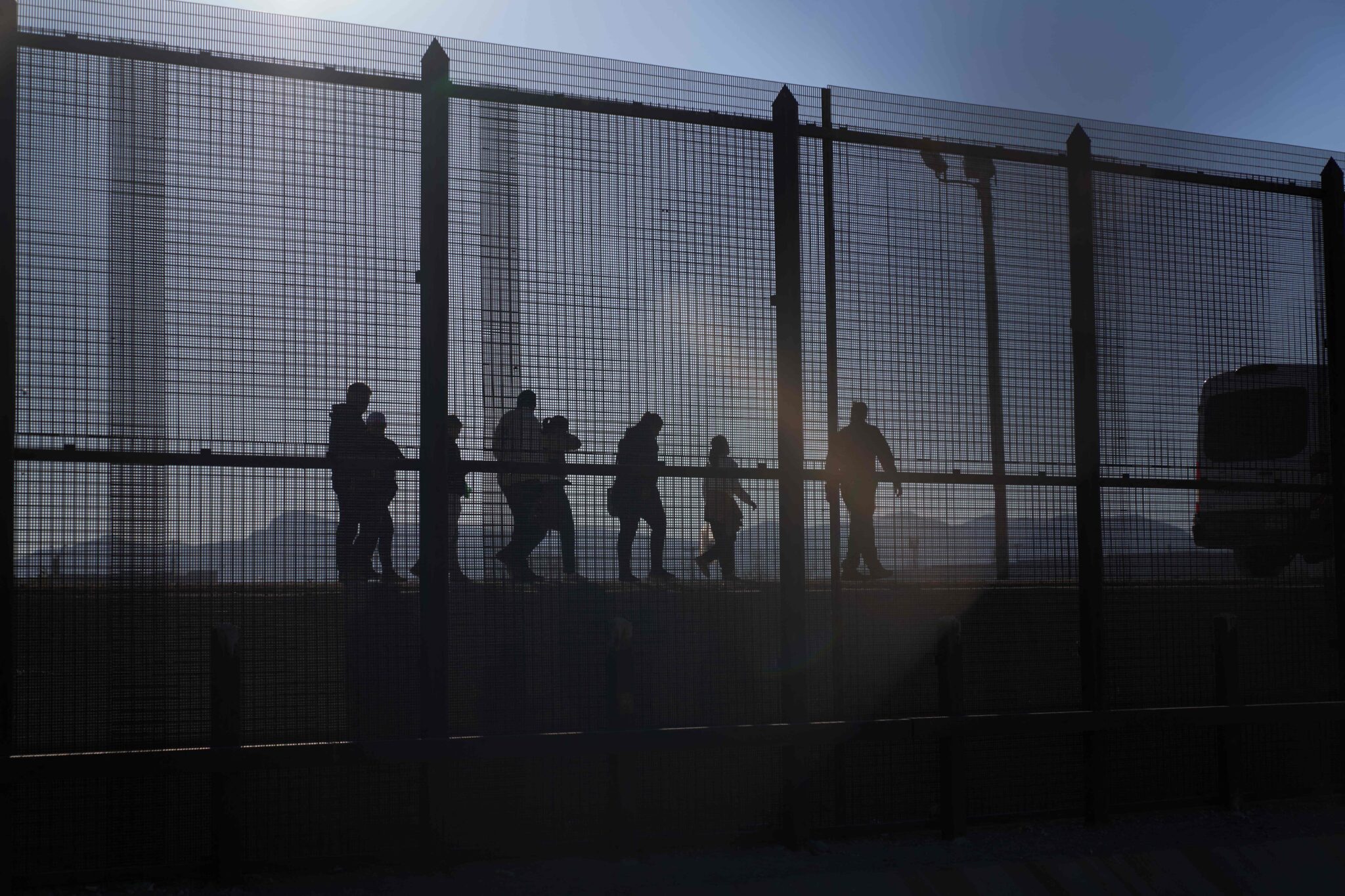 A US Border Patrol agent (L) leads migrants who crossed into the US from Mexico to a van for transportation in El Paso, Texas, on December 21, 2022. - The US Supreme Court halted December 19, 2022 the imminent scrapping of a key policy used since Donald Trump's administration to block migrants at the southwest border, amid worries over a surge in undocumented immigrants. An order signed by Chief Justice John Roberts placed an emergency stay on the removal planned for December 21, 2022 of Title 42, which allowed the government to use Covid-19 safety protocols to summarily block the entry of millions of migrants. (Photo by Allison Dinner / AFP) (Photo by ALLISON DINNER/AFP via Getty Images)