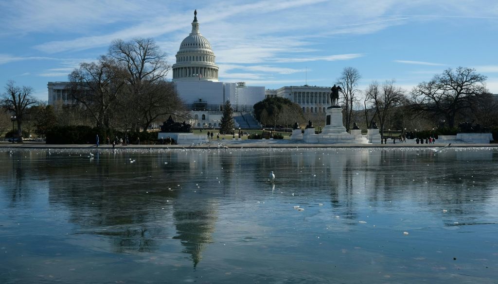 The US Capitol is reflected in Capitol Reflecting Pool in Washington, DC, on December 26, 2022. - Heavy snow, howling winds, and air so frigid it instantly turned boiling water into ice took hold of much of the US over Christmas weekend, including normally temperate southern states. (Photo by Ulysse BELLIER / AFP) (Photo by ULYSSE BELLIER/AFP via Getty Images)