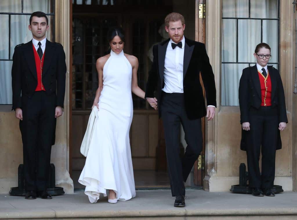 TOPSHOT - The newly married Britain's Prince Harry, Duke of Sussex, (R) and Meghan Markle, Duchess of Sussex, (L) leave Windsor Castle in Windsor on May 19, 2018 after their wedding to attend an evening reception at Frogmore House. (Photo by Steve Parsons / POOL / AFP)        (Photo credit should read STEVE PARSONS/AFP via Getty Images)