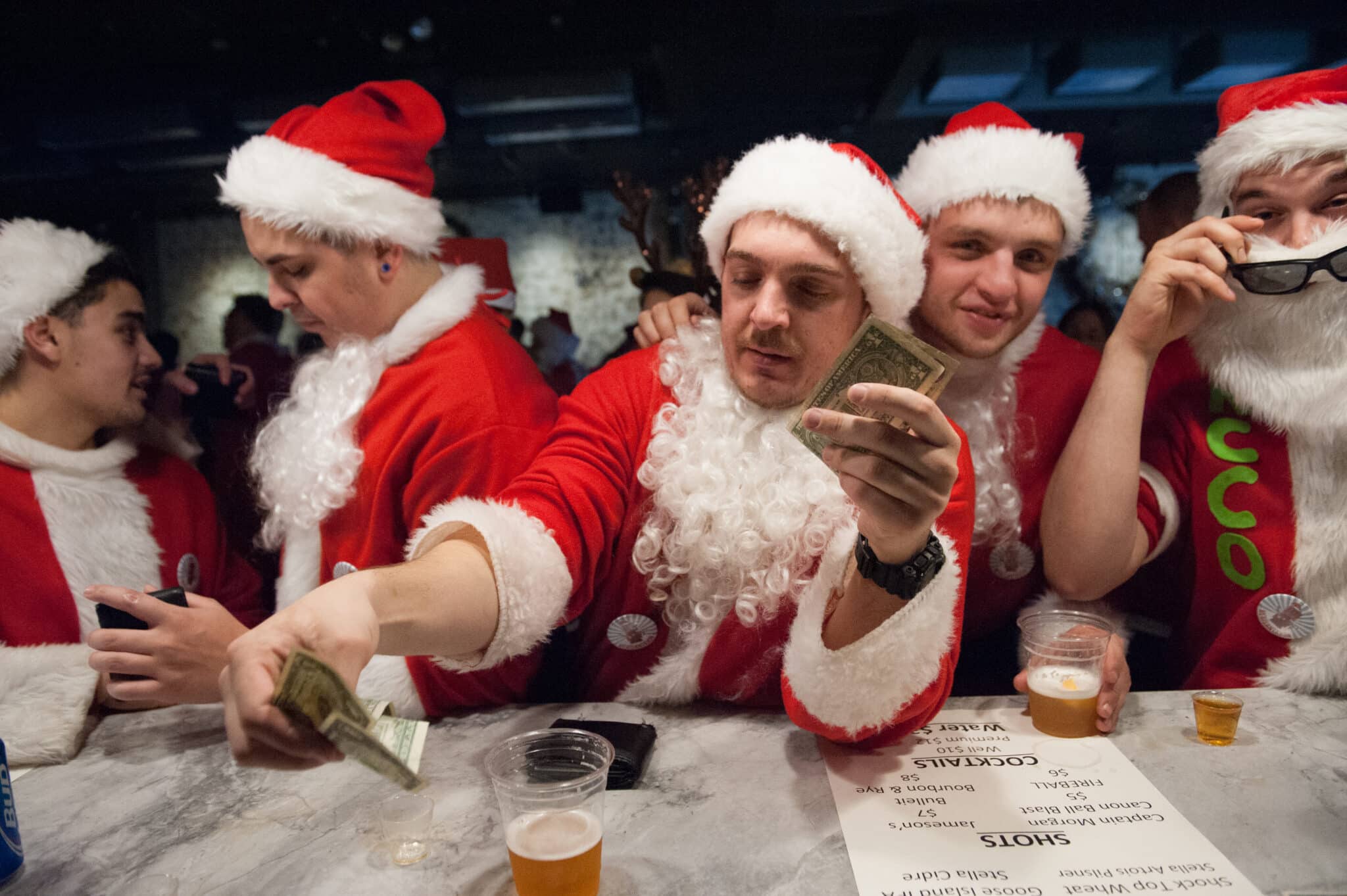 NEW YORK, NY - DECEMBER 12: Men dressed as a Santa drink at a bar called The Hall during the annual SantaCon pub crawl December 12, 2015 in the Brooklyn borough of New York City. Hundreds of revelers take part in the holiday pub crawl, though some local bars and businesses have banned participants in an effort to avoid the typically rowdy SantaCon crowds. (Photo by Stephanie Keith/Getty Images)