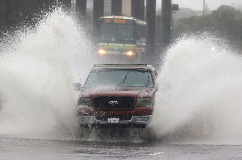 MILL VALLEY, CALIFORNIA - OCTOBER 24: Water kicks up as a truck drives on a flooded street on October 24, 2021 in Mill Valley, California. A category 5 atmospheric river is bringing heavy precipitation, high winds and power outages to the San Francisco Bay Area. The storm is expected to bring anywhere between 2 to 5 inches of rain to many parts of the area. (Photo by Justin Sullivan/Getty Images)