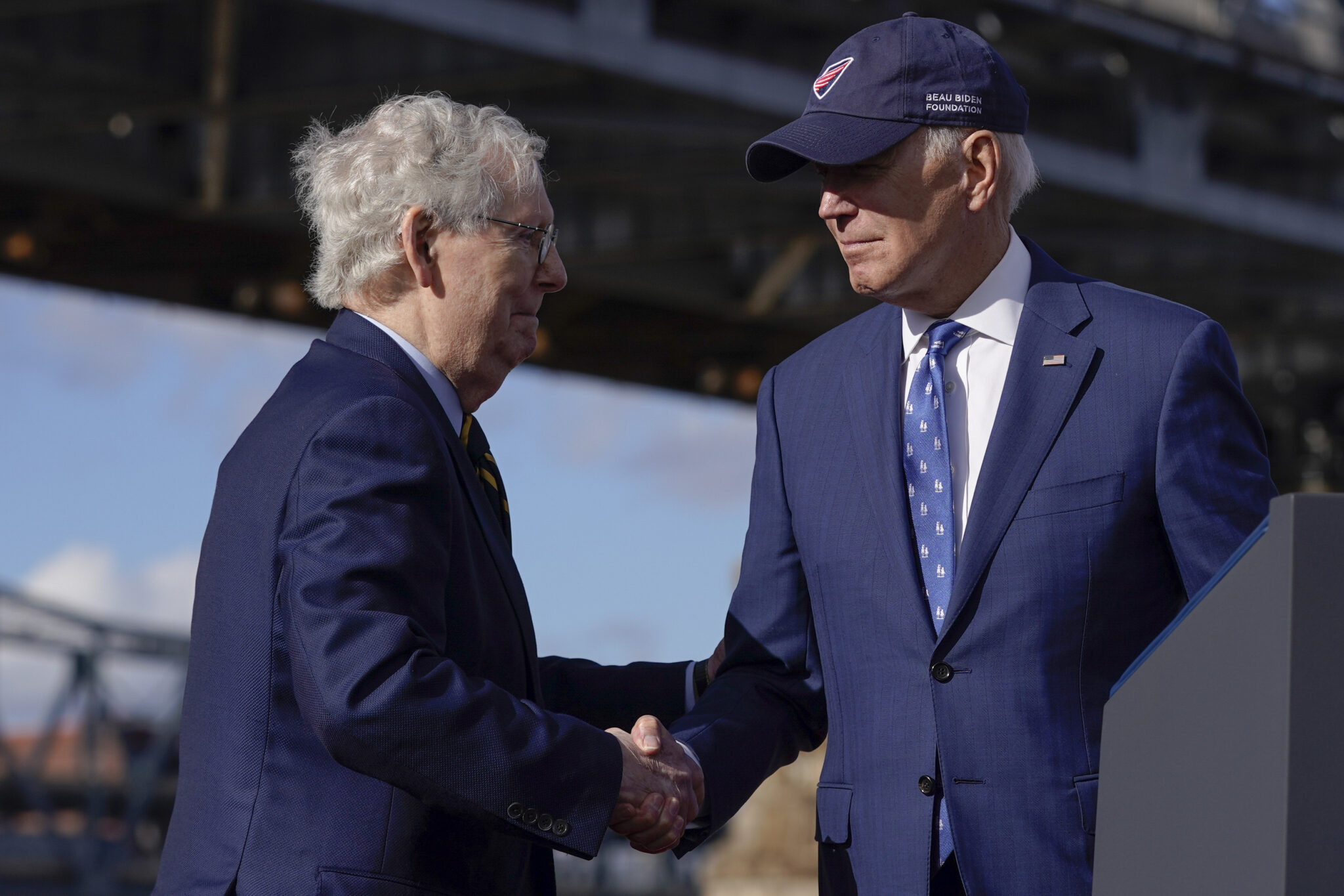 President Joe Biden shakes hands with Senate Minority Leader Mitch McConnell of Ky., after speaking about his infrastructure agenda under the Clay Wade Bailey Bridge, Wednesday, Jan. 4, 2023, in Covington, Ky. Biden's infrastructure deal that was enacted in late 2021 will offer federal grants to Ohio and Kentucky to build a companion bridge that is intended to alleviate traffic on the Brent Spence Bridge, background at left. (AP Photo/Patrick Semansky)