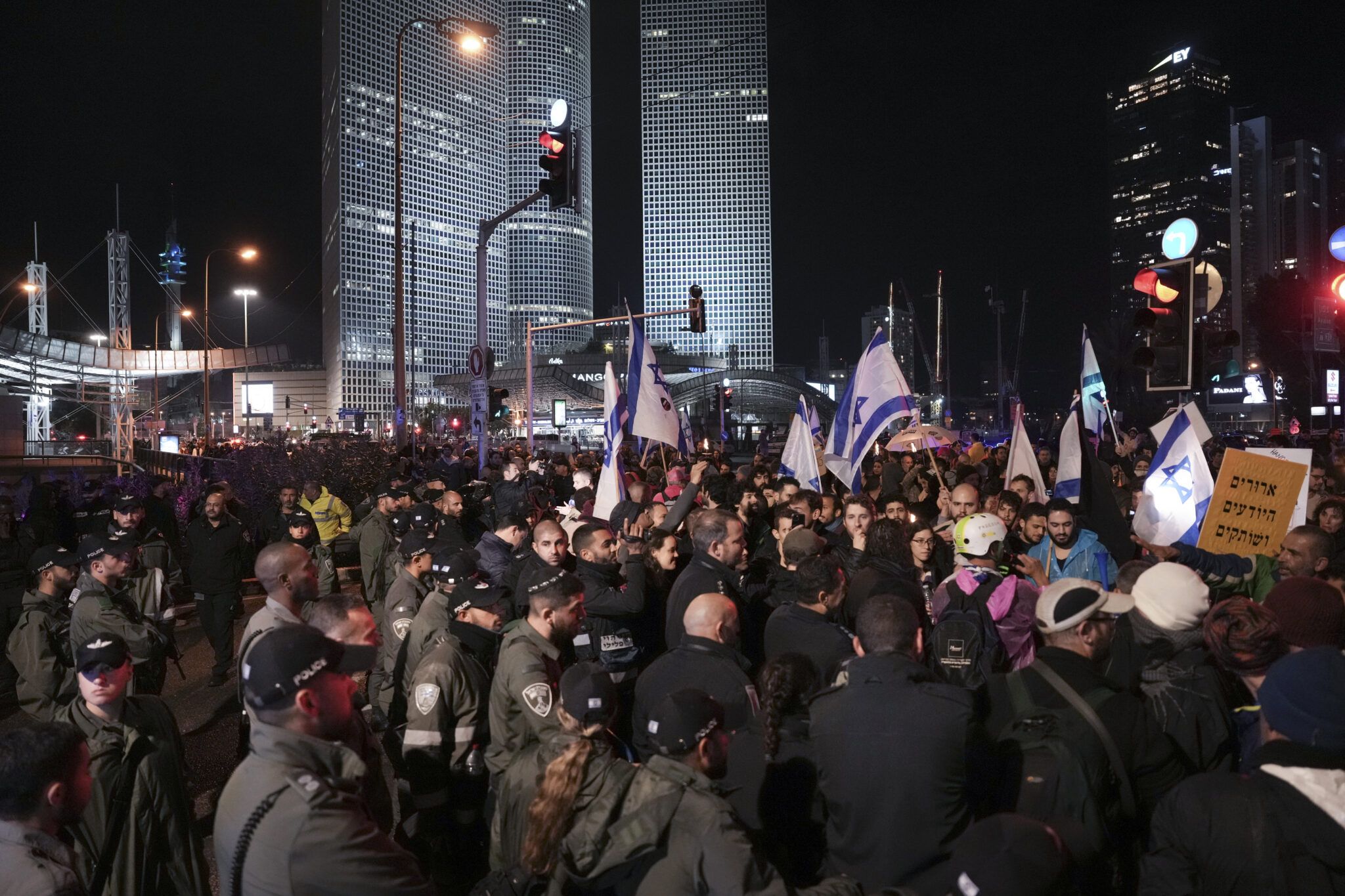 Israeli border police officers prevent protesters from blocking a highway during a rally against the government's plans to overhaul the country's legal system, in Tel Aviv, Israel, Saturday, Jan. 14, 2023. Tens of thousands of Israelis have gathered in central Tel Aviv to protest plans by Prime Minister Benjamin Netanyahu's new government to overhaul the country's legal system and weaken the Supreme Court. (AP Photo/Oded Balilty)