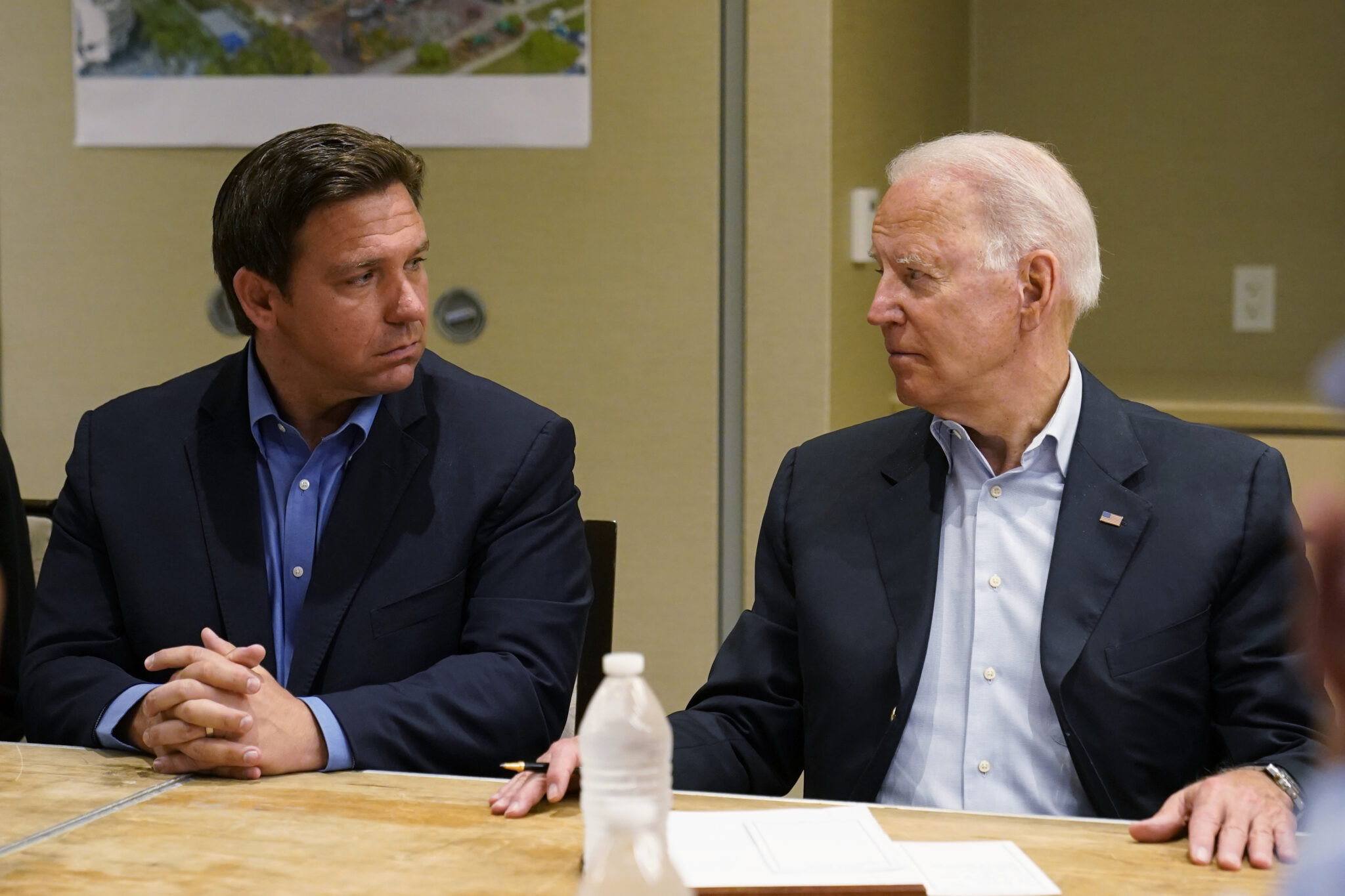 FILE - In this July 1, 2021, file photo President Joe Biden, right, looks at Florida Gov. Ron DeSantis, left, during a briefing with first responders and local officials in Miami on the condo tower that collapsed in Surfside, Fla. As he prepares for a reelection bid next year that could propel him into a presidential campaign, the tragedy in Surfside is exposing voters to a different side of DeSantis. (AP Photo/Susan Walsh, File)