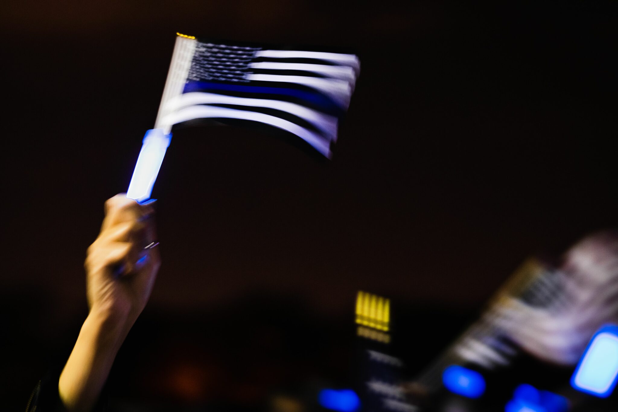 A person waves a thin blue line flag at the United by the Blue Line Vigil organized by the El Paso Police Wives and Family Support Organization at Album Park in El Paso, Texas on November 7, 2020. - Democrat Joe Biden has won the White House, US media said November 7, defeating Donald Trump and ending a presidency that convulsed American politics, shocked the world and left the United States more divided than at any time in decades. (Photo by Justin HAMEL / AFP) (Photo by JUSTIN HAMEL/AFP via Getty Images)