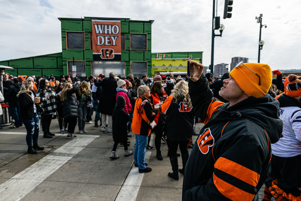 CINCINNATI, OH - FEBRUARY 13: A Bengals fan takes a video on his phone at The Banks Riverfront Entertainment District on February 13, 2022 in Cincinnati, Ohio. Fans are gathering to watch the Cincinnati Bengals play the Los Angeles Rams in Super Bowl LVI.. (Photo by Jon Cherry/Getty Images)