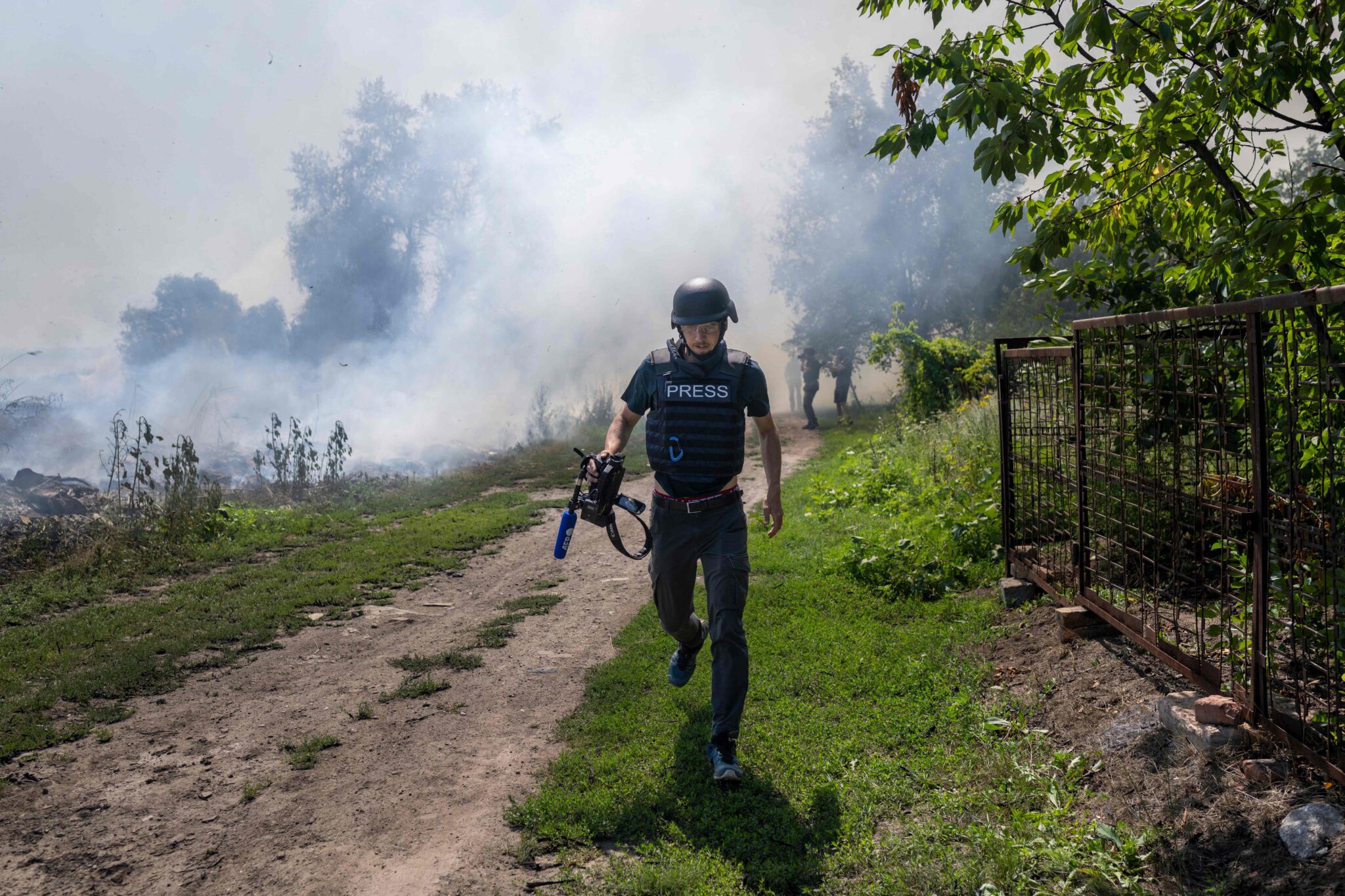 An AFP journalist runs as smoke rises behind after a bombardment in Bakhmut, Eastern Ukraine, on July 31, 2022. (Photo by BULENT KILIC / AFP) (Photo by BULENT KILIC/AFP via Getty Images)
