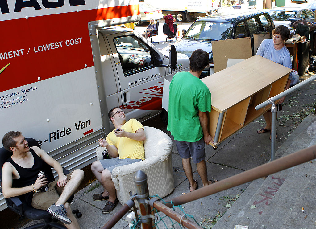 BOSTON - SEPTEMBER 1: Friends that are there to help, Nigel Durham, and Tom Costic, just seem to be in the way as Patrick Manian and Gray Dunla maneuver furniture to a U-Haul truck outside their Ashford students moving in and out of apartments on Sept 1. They all are BU graduates. (Photo by Joanne Rathe/The Boston Globe via Getty Images)