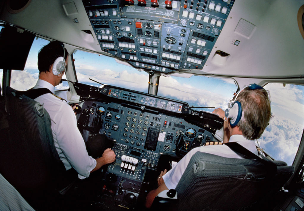 pilots wearing headsets in the cockpit of a BAE 146 flying. (Photo by: aviation-images.com/Universal Images Group via Getty Images)