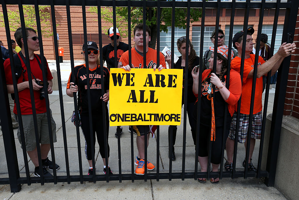 BALTIMORE, MD - APRIL 29: Fans stand outside of the ballpark as the Baltimore Orioles play the Chicago White Sox at an empty Oriole Park at Camden Yards on April 29, 2015 in Baltimore, Maryland. Due to unrest in relation to the arrest and death of Freddie Gray, the two teams played in a stadium closed to the public. Gray, 25, was arrested for possessing a switch blade knife April 12 outside the Gilmor Houses housing project on Baltimore's west side. According to his attorney, Gray died a week later in the hospital from a severe spinal cord injury he received while in police custody. (Photo by Patrick Smith/Getty Images)